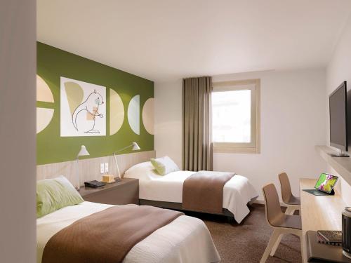 Habitación de hotel con 2 camas y TV en ibis Styles Guéret, en Guéret