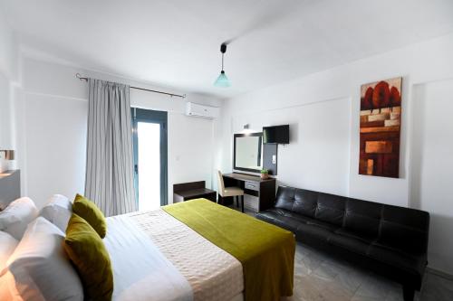 a bedroom with a bed and a couch at Telis Hotel in Agia Paraskevi