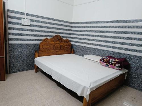 un letto in una stanza con parete a righe di OYO Bismillah Hotel & Lodge 