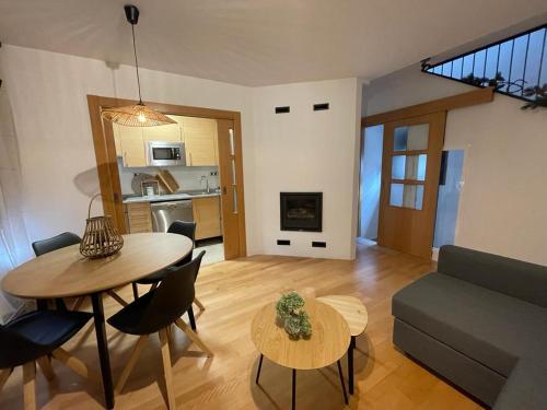 una sala de estar con una mesa y un sofá en Apartamento La Añaza, en Villanúa