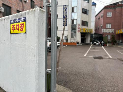 um sinal numa parede ao lado de um parque de estacionamento em Sang Il Jang em Mokpo