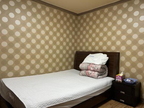 a small bed in a bedroom with polka dot wallpaper at Sang Il Jang in Mokpo