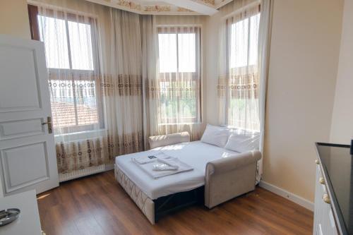 a bedroom with a bed and a couch and windows at IQ Hotel Galatasaray in Istanbul
