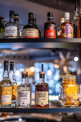 a shelf with several bottles of whiskey on it at Pier 5 Hotel in Aalborg