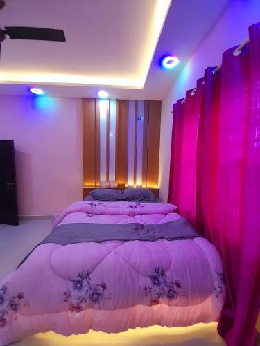 um quarto com uma cama com iluminação rosa em York Air B & B em Kathmandu