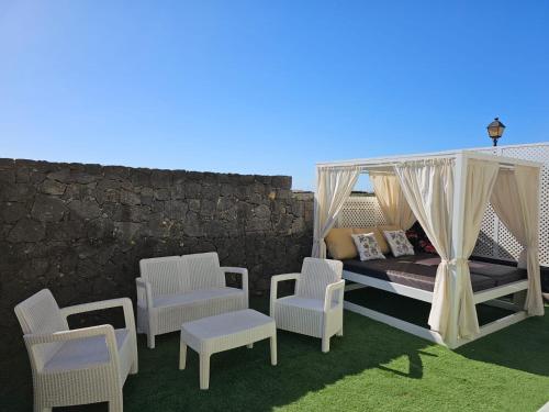 a room with a bed and chairs and a wall at Villa Portugal - VipVipVillas in Tahiche
