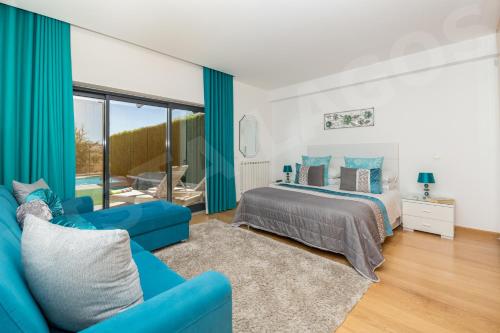 ラゴスにあるCasa Vista da Lagosのベッドルーム(青いベッド1台、青いソファ付)