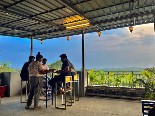 a group of people sitting at a table on a patio at Green Horizon, Luxury & Nature at Kothamangalam in Kotamangalam