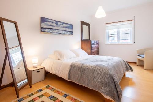 1 dormitorio con cama y espejo en Casa dos Minaus by LovelyStay, en Santo Isidoro