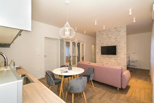 a living room with a pink couch and a table at Studio apartments Marcel in Split
