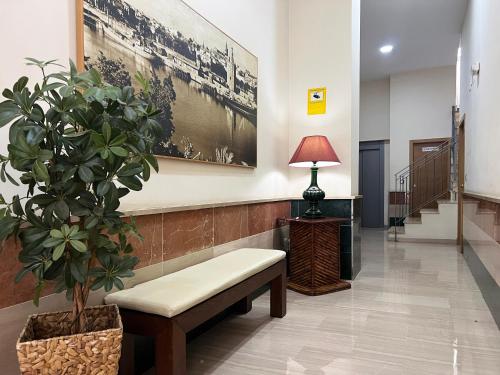 a waiting room with a bench and a potted plant at Suite Apartment City Center - Aloha Sevilla in Seville