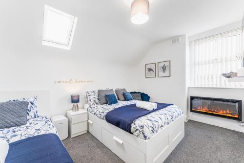 a bedroom with two beds and a fireplace at Luxury Stay - Parking, Close City Centre, Netflix & Disney, in Nottingham