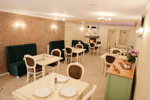 a restaurant with tables and chairs and a brick wall at Pensiune Agroturistica Molidu in Almaş