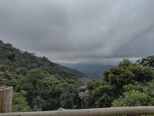 a view of a valley with trees and clouds at Sítio Werly in Domingos Martins