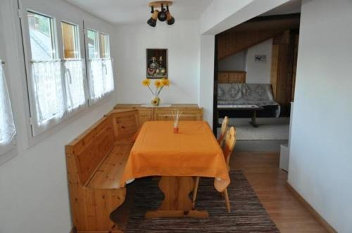 una sala da pranzo con tavolo in legno in una stanza di Unterkunft a Zernez