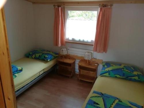 una piccola camera con due letti e una finestra di Unterkunft a Zernez
