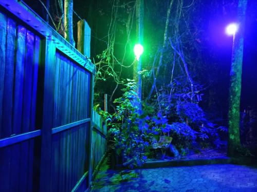 a house with a fence and a garden at night at Sítio Werly in Domingos Martins