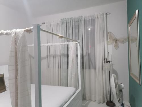 a white room with a crib with a butterfly on it at Villa Ada Luxury Retreat in Juan Dolio