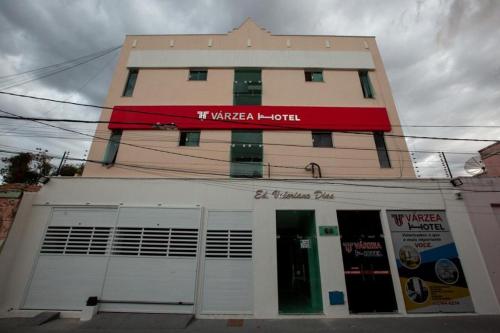 a building with a red sign on top of it at Várzea HOTEL in Sobral