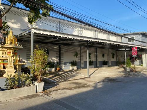 un edificio con plantas frente a una calle en SS GUESTHOUSE, en Ban Map Prasoe