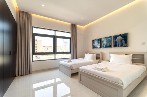a bedroom with two beds and a large window at Beautifully furnished 3BDR in Al Sidir Greens in Dubai