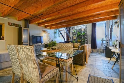 a dining room with a glass table and wicker chairs at Casa da Escola in Cacia