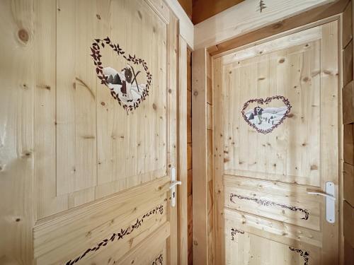 a room with wooden walls and two hearts on the wall at CH201 Chalet 6 Pers in Les Carroz d'Araches