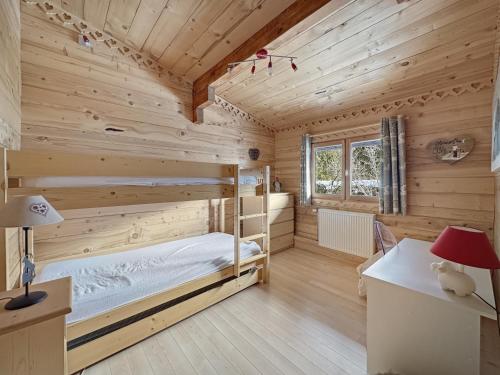 a log cabin bedroom with a bed and a desk at CH201 Chalet 6 Pers in Les Carroz d'Araches