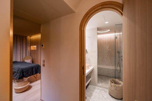 a room with a bathroom with a shower and a bedroom at Hôtel Madison in Paris