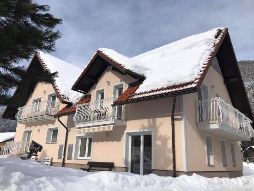 a house with snow on the roof at Apartmaji Misotič in Gozd Martuljek