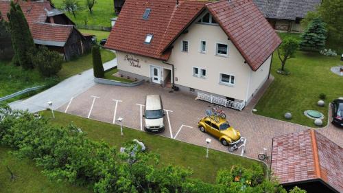 a house with a car parked in a parking lot at Apartmaji Misotič in Gozd Martuljek