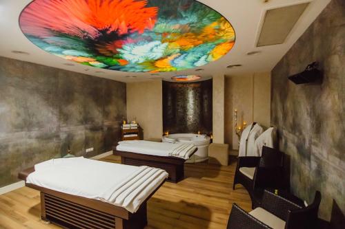 a room with two beds and a bath tub at JRW Welmond Hotel in Batumi