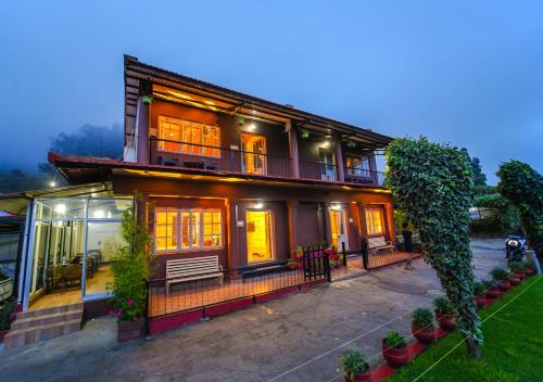 a large house with a porch and a balcony at Silent Valley Resort Ooty by VOYE HOMES in Ooty
