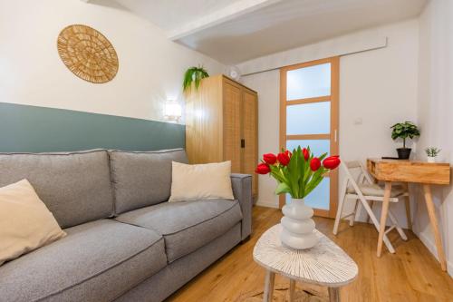 a living room with a couch and a table with flowers at Studio cozy centre avec Parking in Grasse