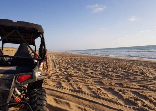 a jeep driving down a sandy beach at MEHDIA PLAYA in Kenitra