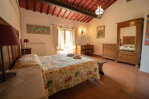 um quarto com uma cama, uma cómoda e um espelho em Agriturismo Il Cocco em Montalcino