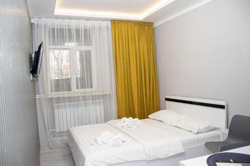 a bedroom with a white bed and a window at AG Hotel in Almaty