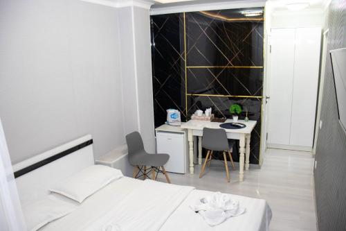 a bedroom with a bed and a table and chairs at AG Hotel in Almaty