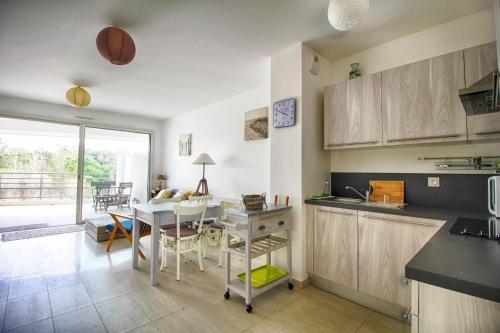 une cuisine avec une table et une salle à manger dans l'établissement Appartement Les Rivages Calvi, à Calvi