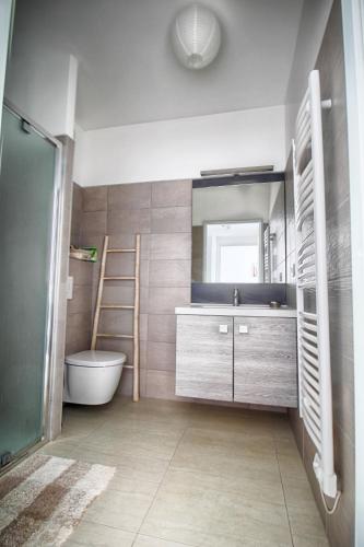 La salle de bains est pourvue d'un lavabo, d'un miroir et d'une échelle. dans l'établissement Appartement Les Rivages Calvi, à Calvi