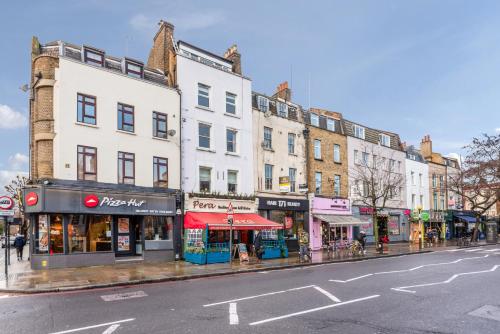 a busy city street with buildings and shops on a street at Modernised Apartments 1 and 2 Bedrooms Option Terrace and Balcony High Street in London