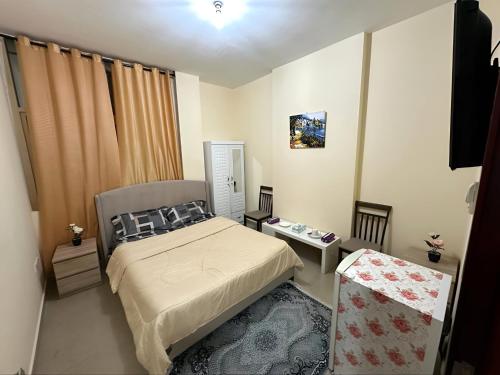 a small bedroom with a bed and a table at Fabulous Luxury Room in Abu Dhabi