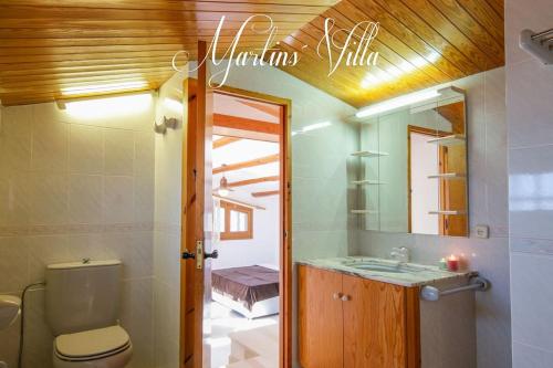 a bathroom with a toilet and a sink and a mirror at Martin 's Villa. House on the beach with pool in Lloret de Mar