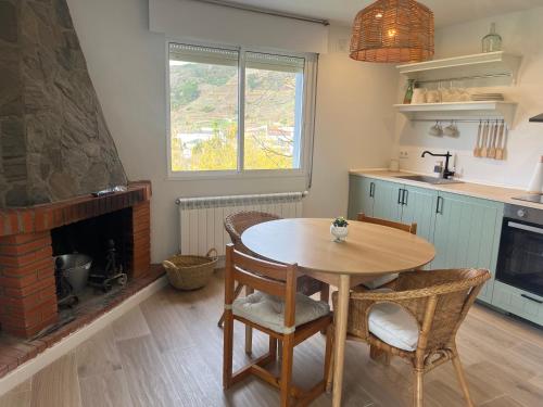 a kitchen with a wooden table and a fireplace at Casa Catalina - Ribeira Sacra in Abeleda