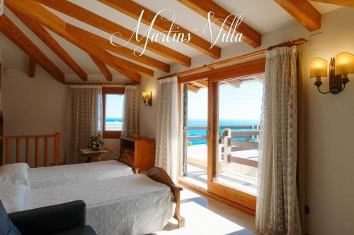 a bedroom with a bed and a view of the ocean at Martin 's Villa. House on the beach with pool in Lloret de Mar