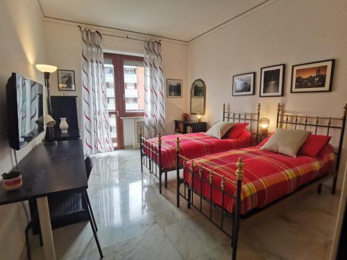 1 dormitorio con 2 camas, mesa y escritorio en Appartamento a 20 minuti dal Centro, Zona Residenziale Tranquilla, Free Parking, 2 Camere, 5 posti letto en Turín