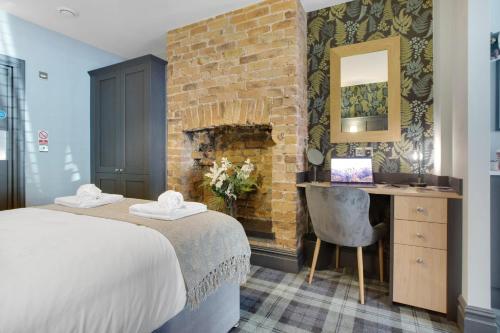 1 dormitorio con cama, escritorio y pared de ladrillo en Urban Elegance - Luxe 1-Bed Haven in Hartlepool, en Hartlepool