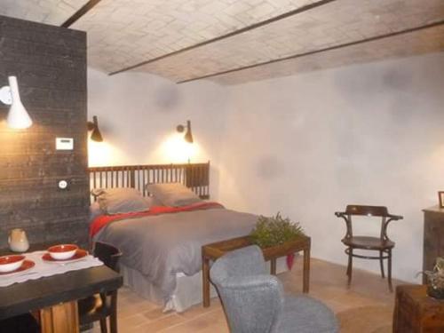 a bedroom with a bed and a chair and a table at FONT DE RAINE in Rottier
