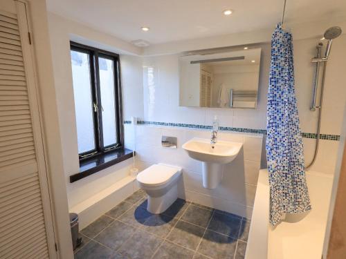 a bathroom with a white toilet and a sink at 9 Camden Building in Kendal