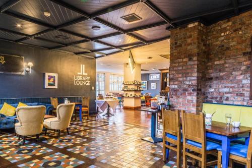 a restaurant with tables and chairs and a brick wall at The Donard Hotel in Newcastle